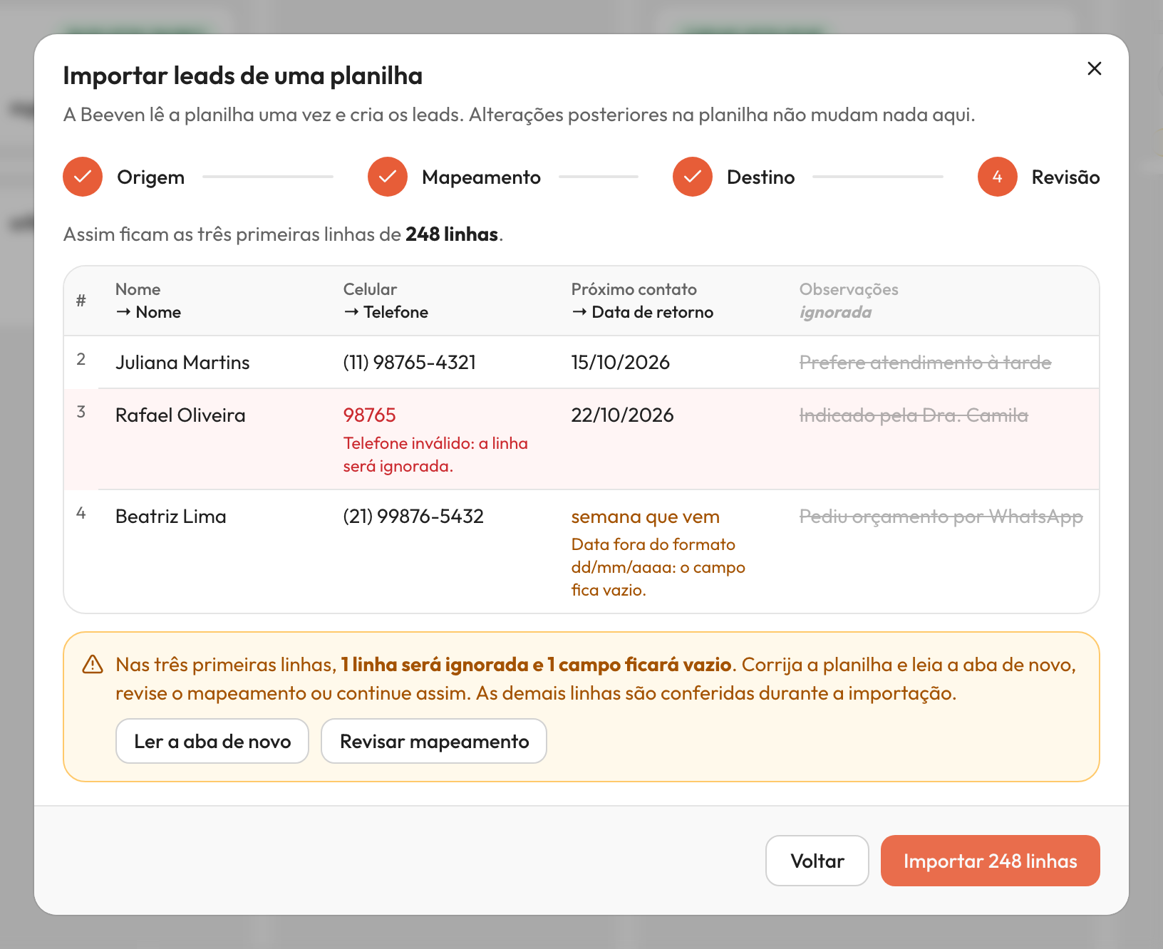 Passo 'Revisão' da importação com uma tabela de três linhas de dados fictícios. As colunas mostram o mapeamento, uma linha com telefone inválido destacada como ignorada e uma célula de campo personalizado inválida com aviso de que ficará vazia.